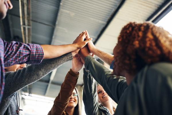 Gruppe Studierende, die sich High Five gibt